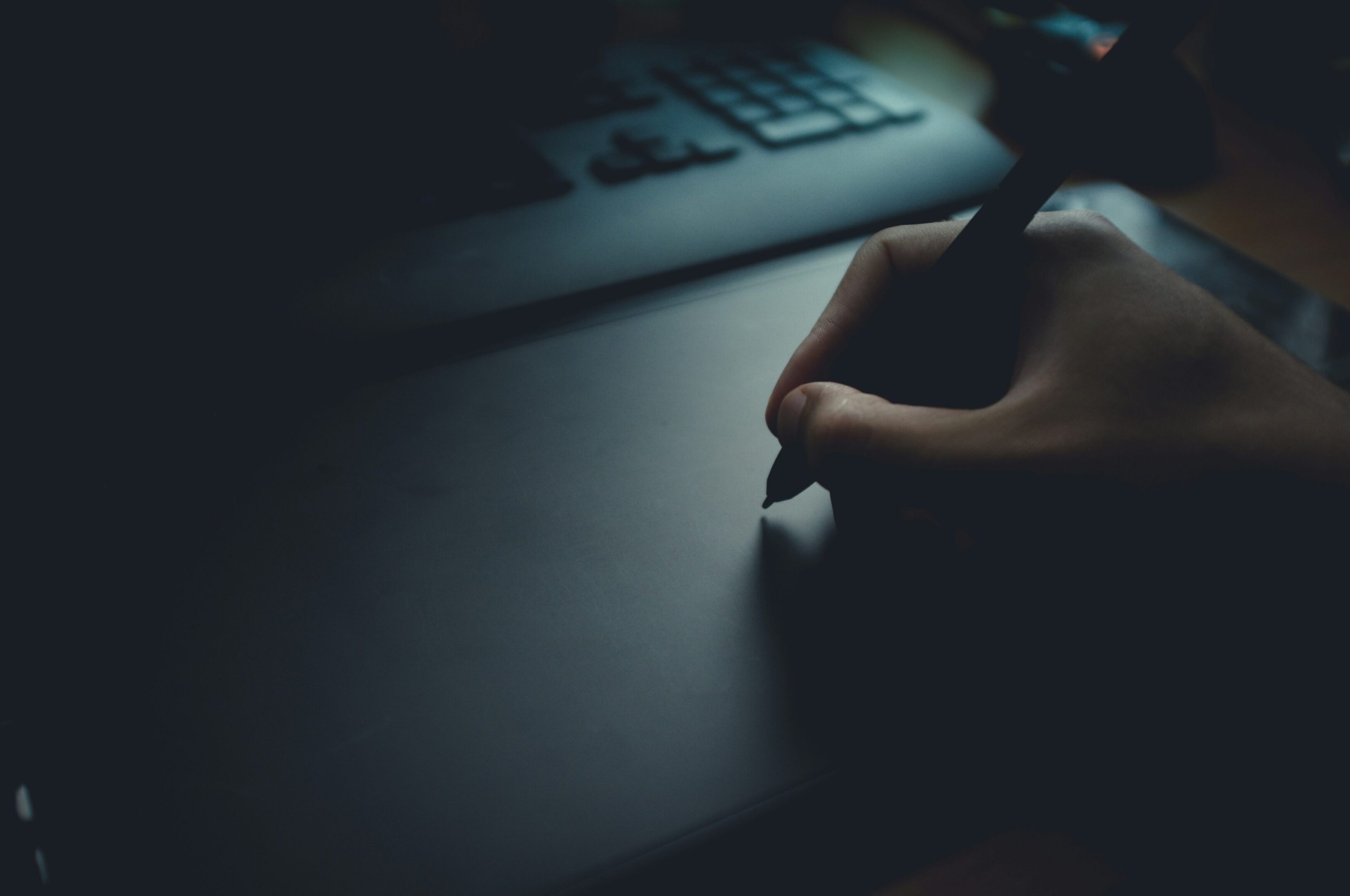 A person writing on the keyboard of a laptop.