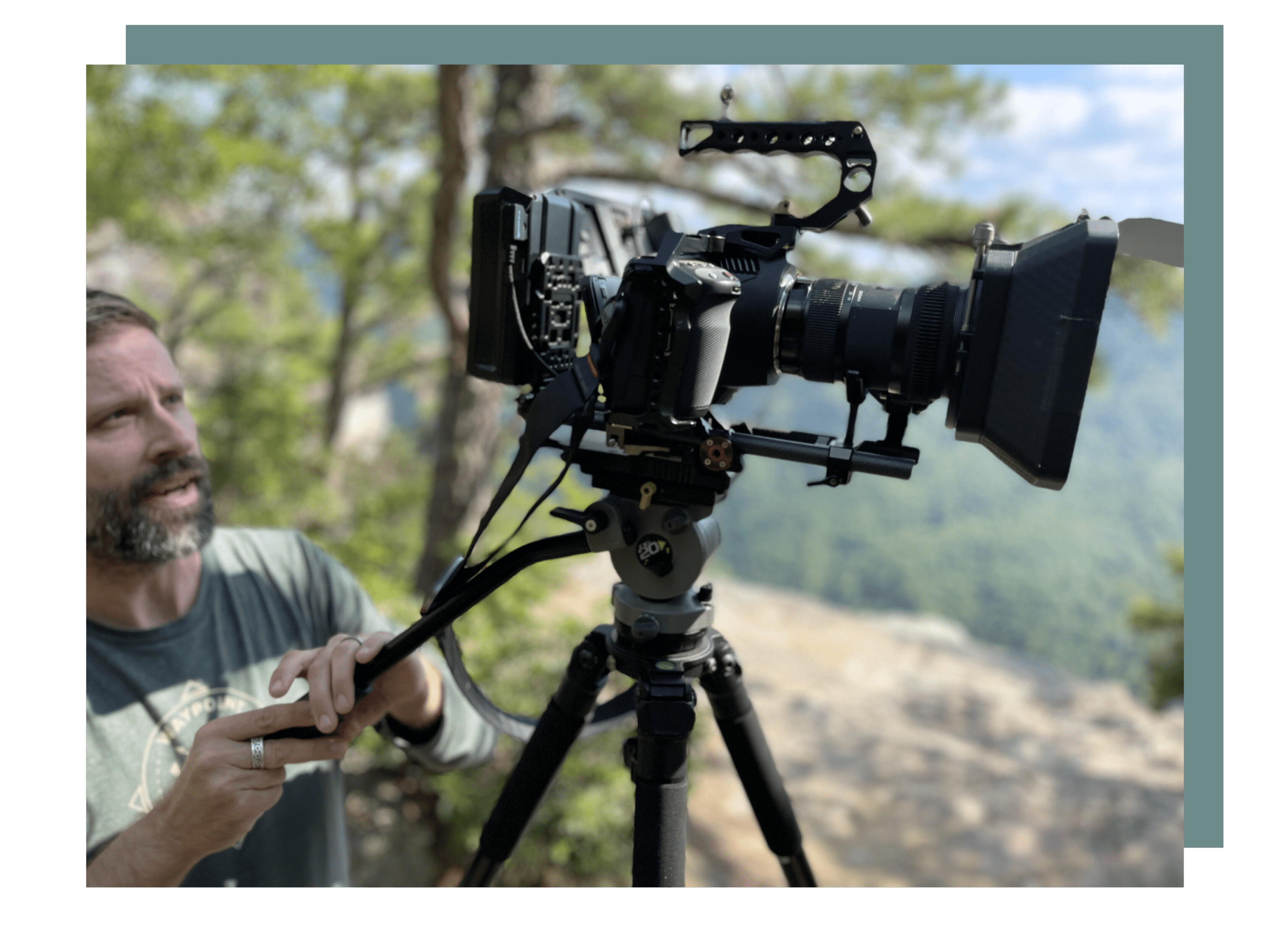 A man is holding his phone while standing next to a camera.