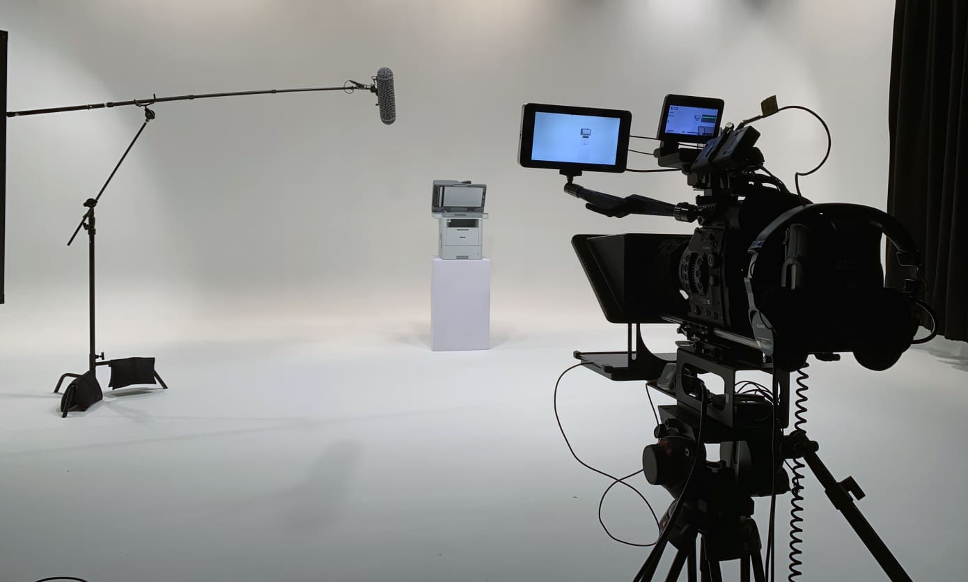 A camera is set up in front of a white wall.